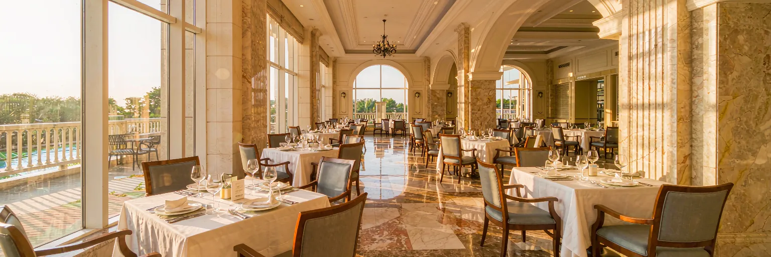 Warm boutique hotel restaurant dining room with elegant tables and morning light